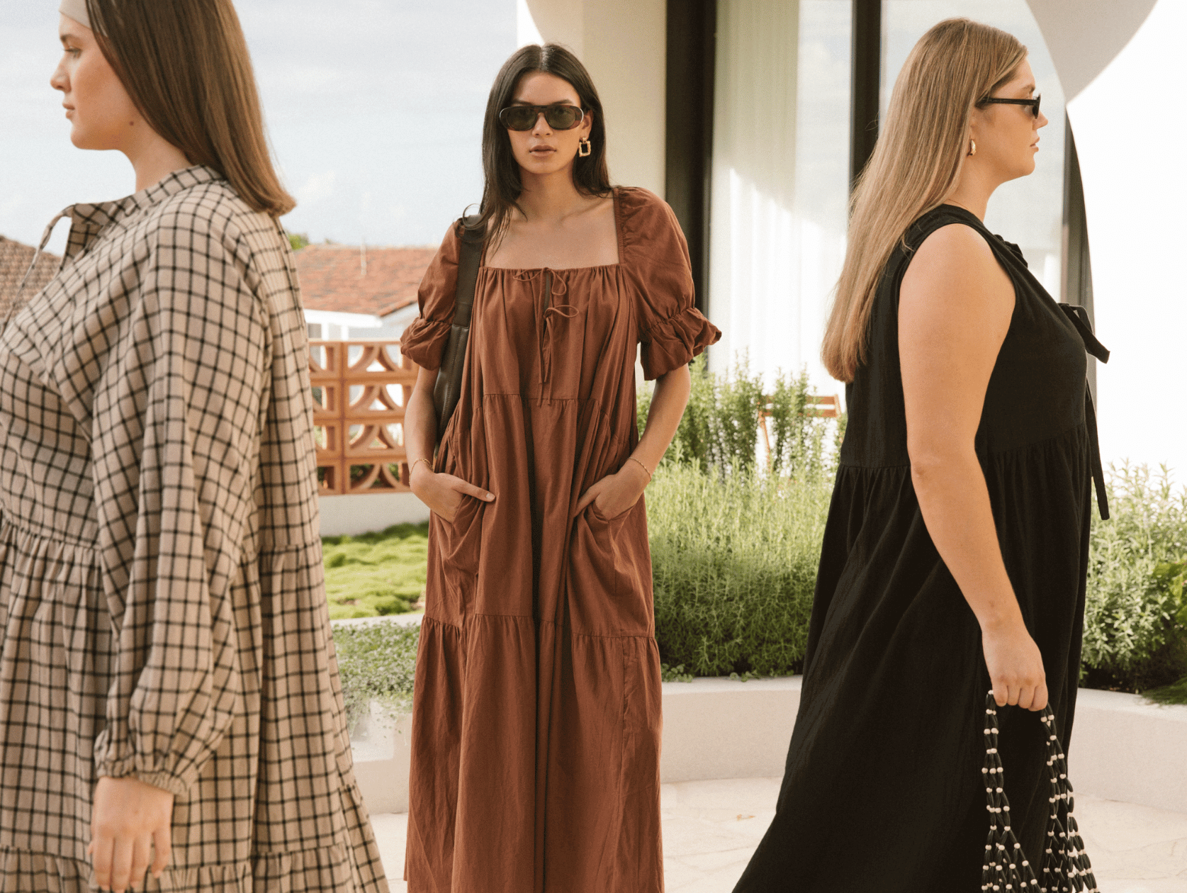 Three women wearing linen printed sets, relaxed sitting on stairs outside in a fashionable manner