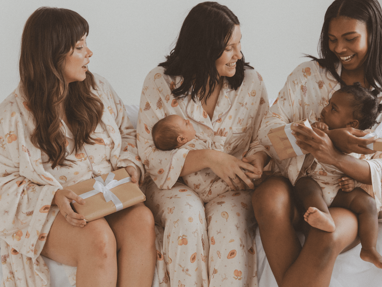 three mothers holding babies in the lullaby club x little and fern exclusive pyjams cozy comfy breastfeeding friendly mothers day gifts