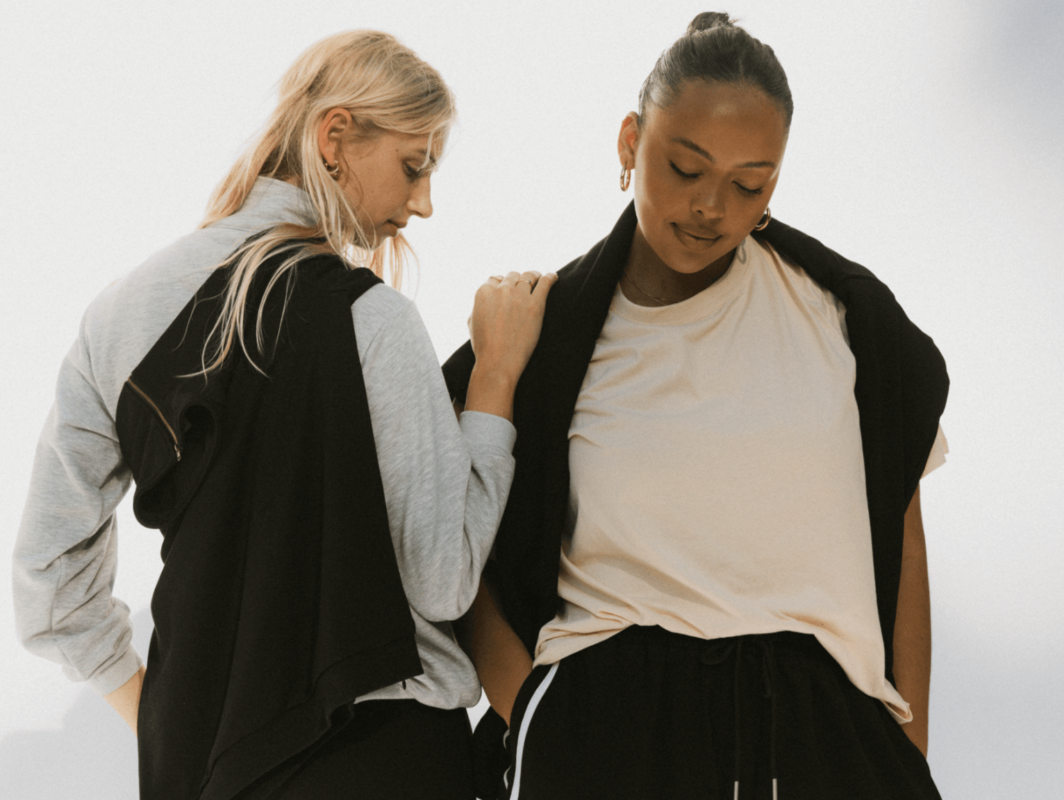 Two women standing next to each other posing, wearing tracksuit sets