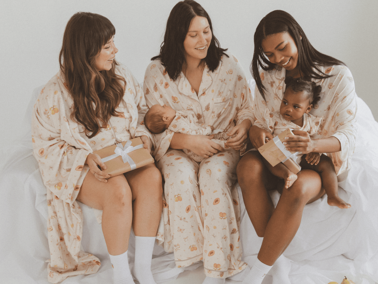 Three women wearing linen printed sets, relaxed sitting on stairs outside in a fashionable manner