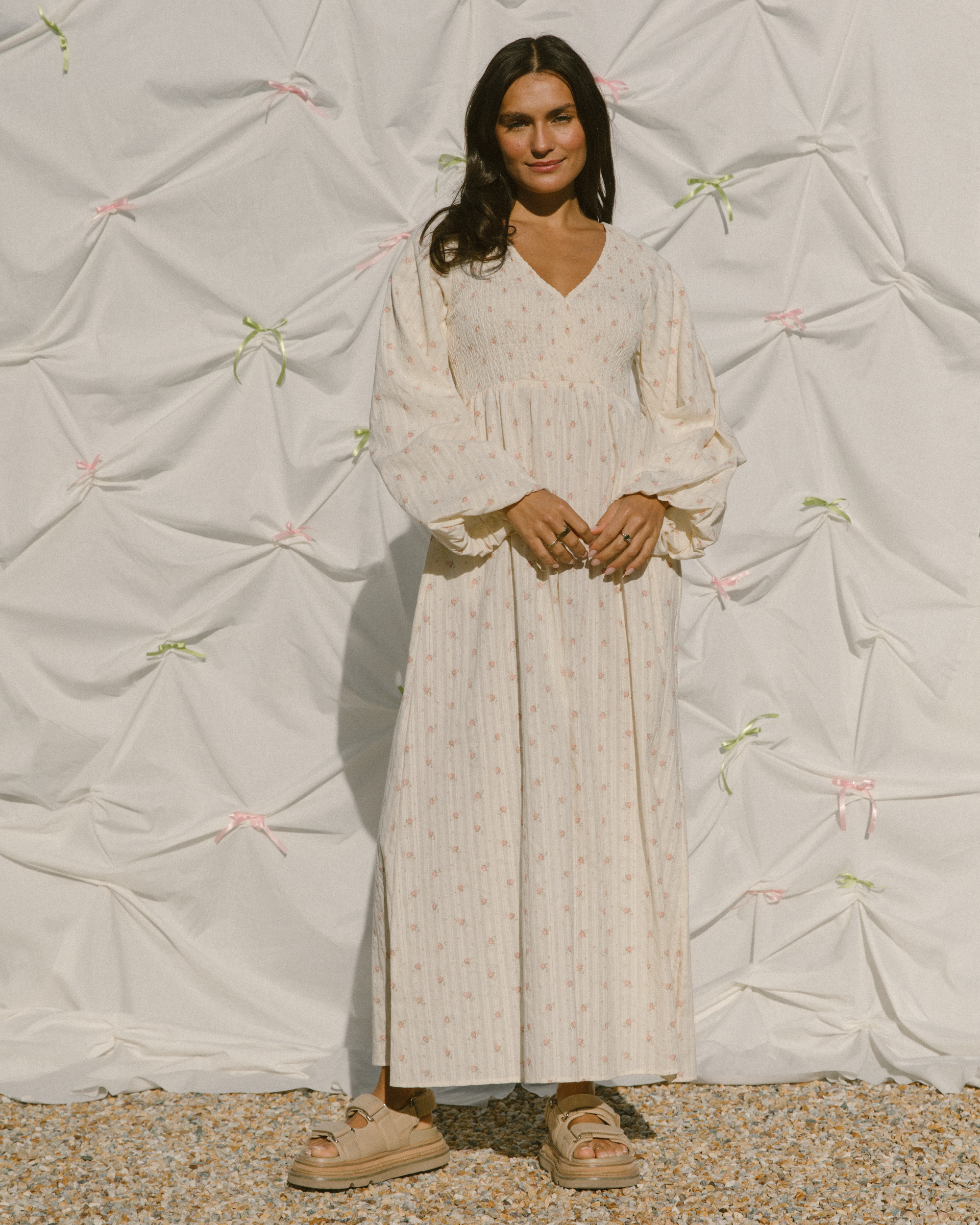 Woman wearing feminine silhouette maxi dress in a cottage core print.