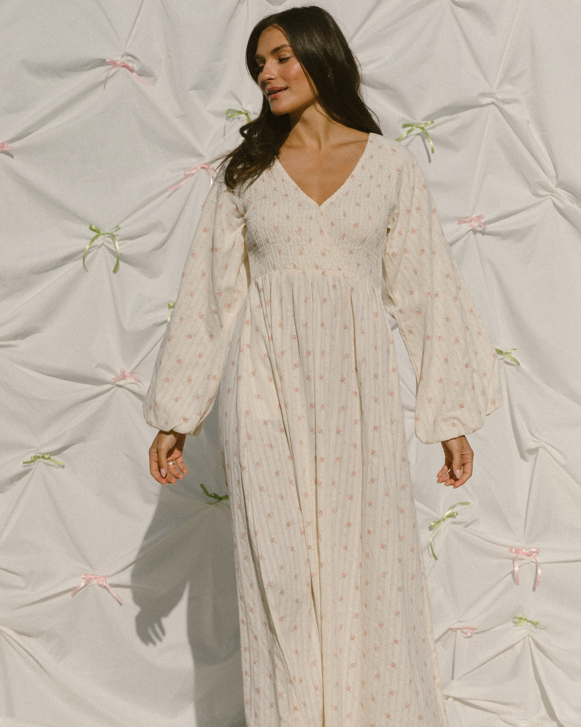 Woman wearing fairy inspired flowy maxi dress with shirred wrap bust and long billowing sleeves.