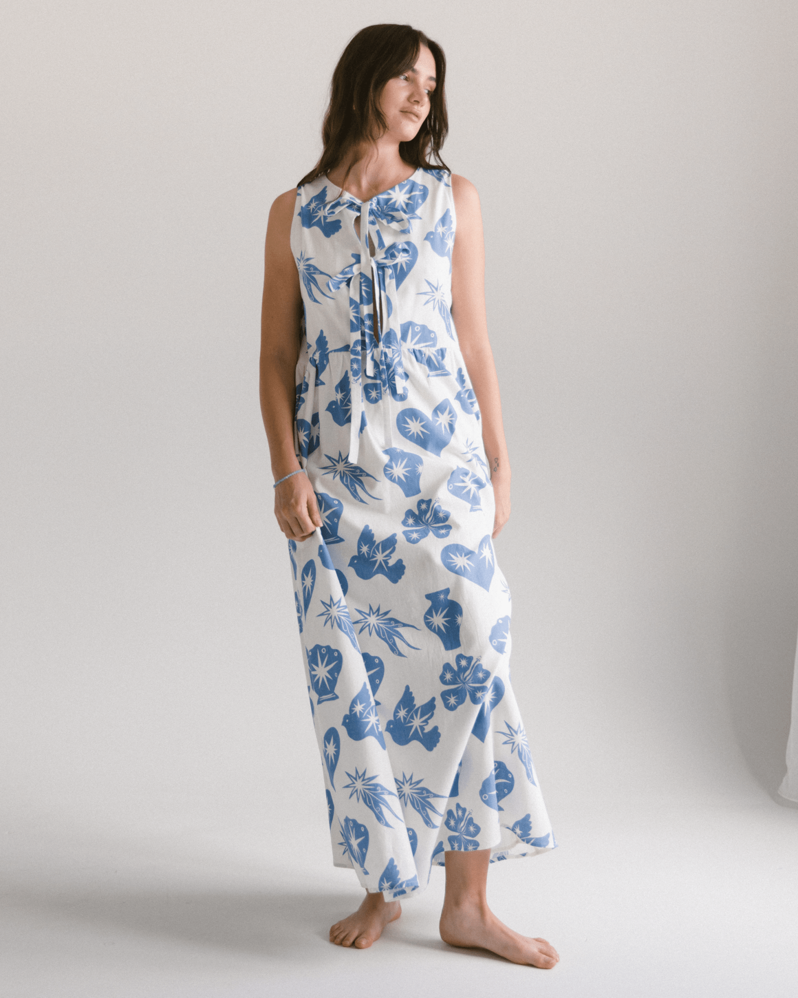 Woman wearing a blue floral dress on a plain background
