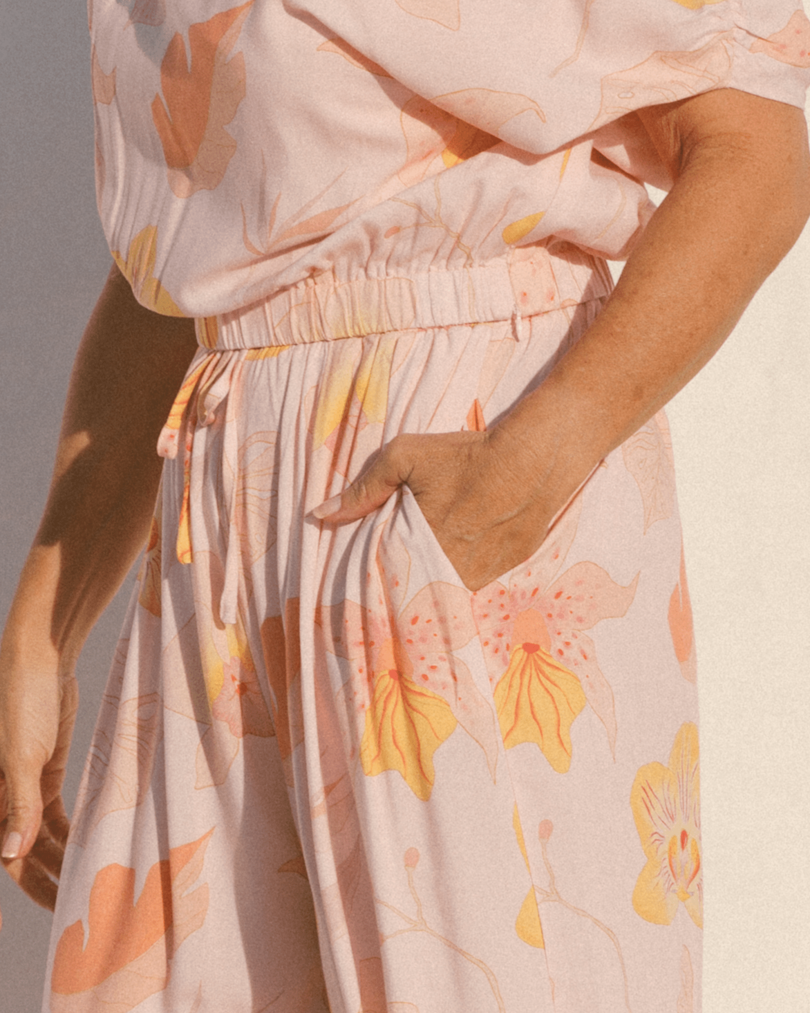 Close-up of elastic waistband of crop top & pocket of wide legged lounge pants.