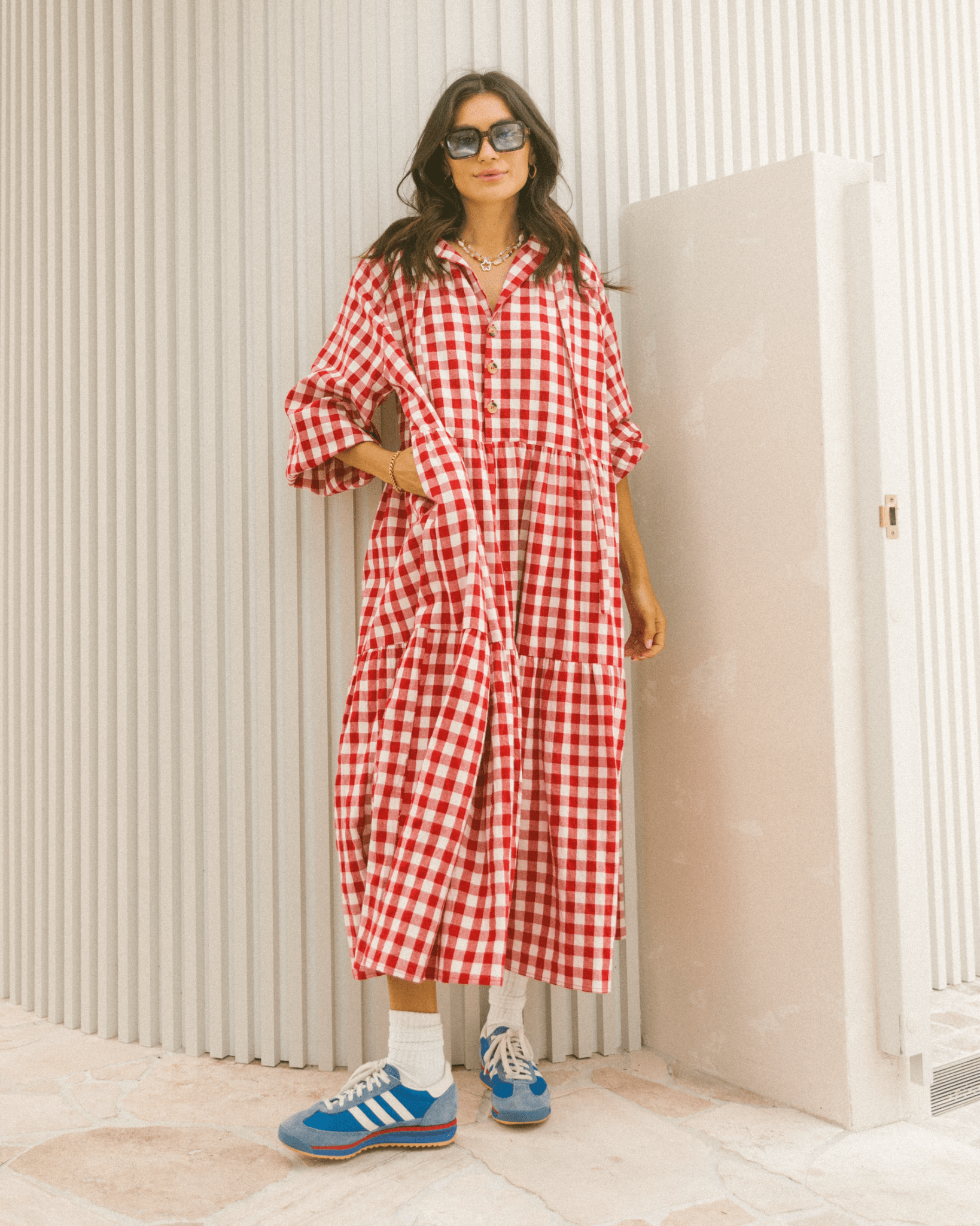Woman in flowy postpartum-friendly maxi dress in red gingham