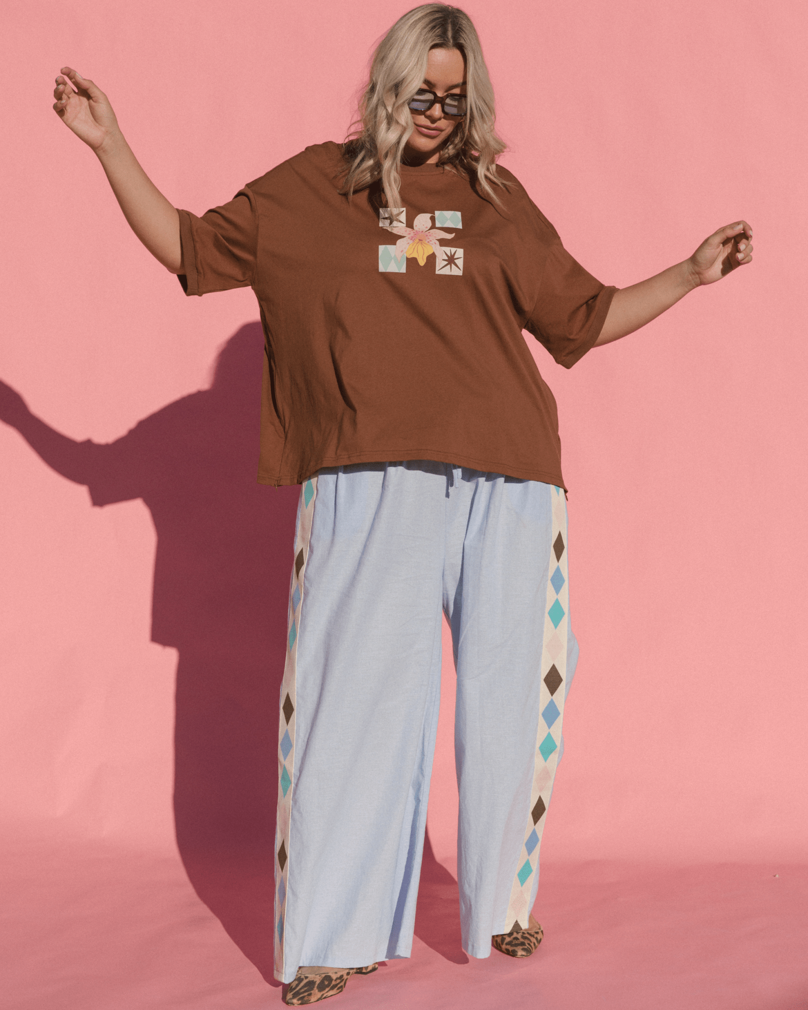 Woman wearing stylish wide-fit maternity tshirt with breastfeeding access and wide-legged adjustable pants.