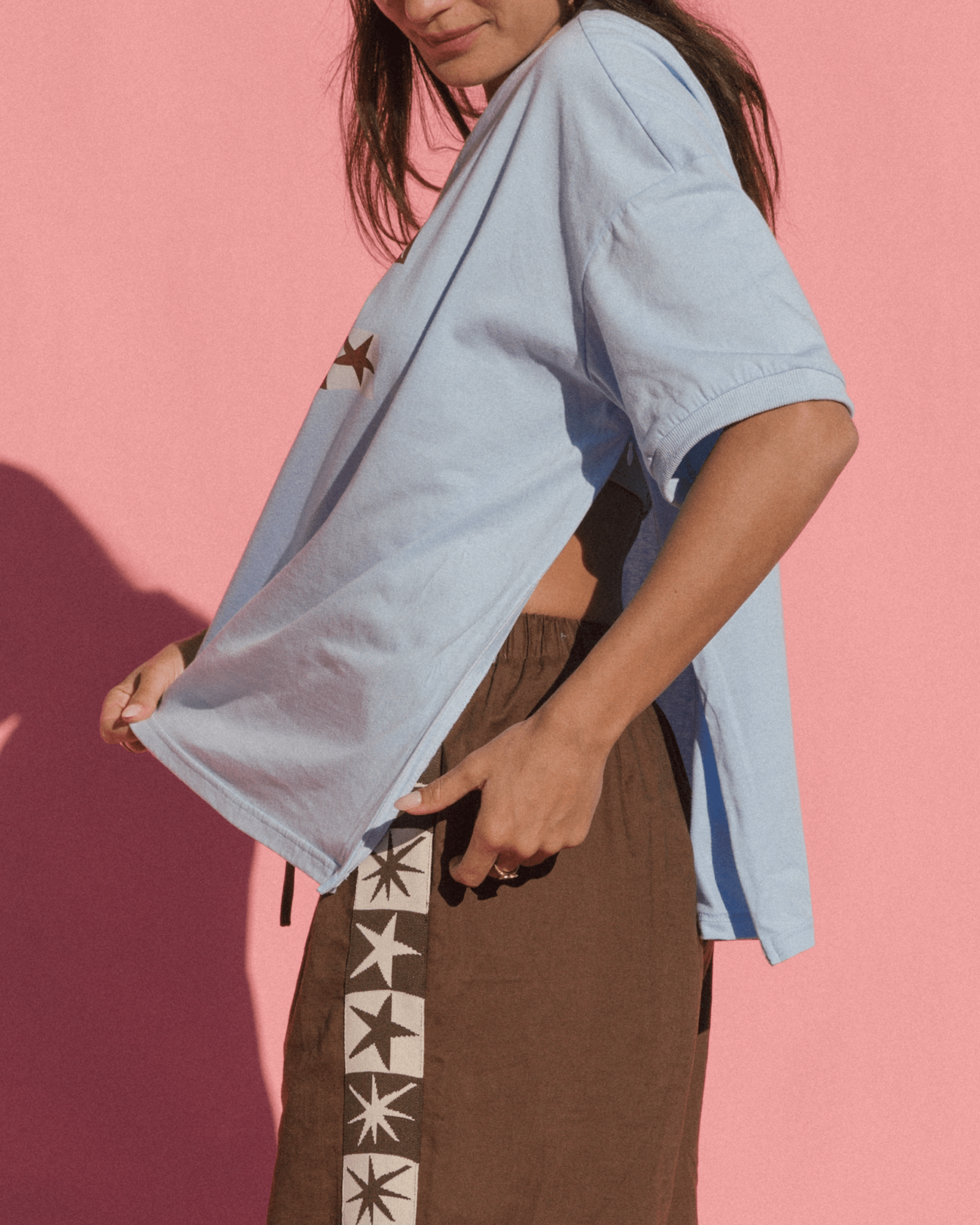 Woman showing breastfeeding accessibility via side-seam zips on a blue oversized maternity friendly tshirt.