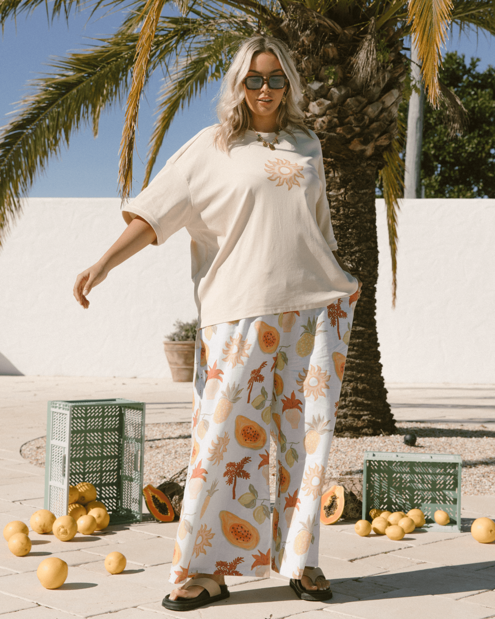 Women swaying in her oversized loungewear, featuring a slouchy, oversized maternity friendly tshirt & wide legged blue, summer printed full length lounge pants.