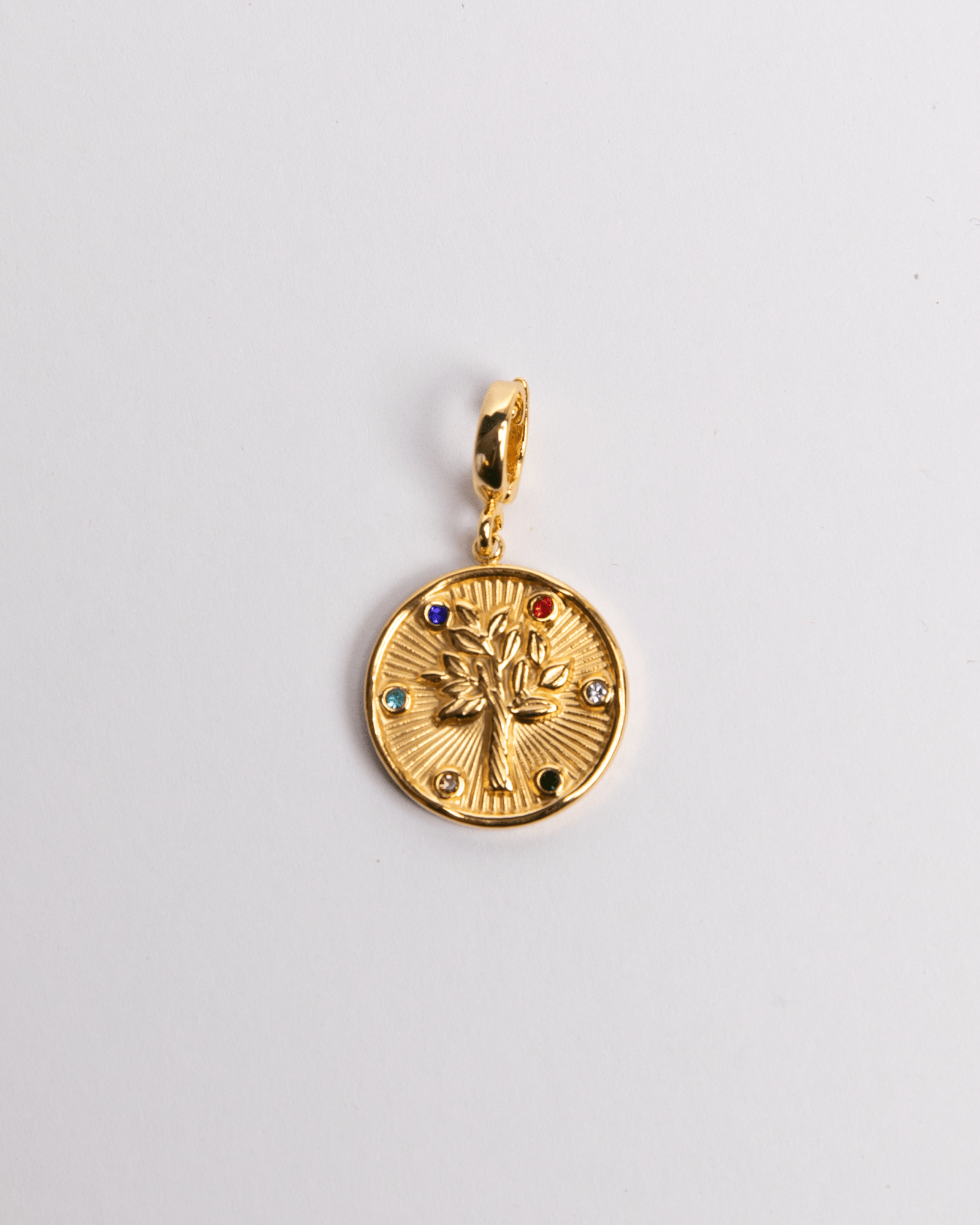 A gold-plated stainless steel charm featuring the Tree of Life design with a sunburst pattern and small decorative stones.