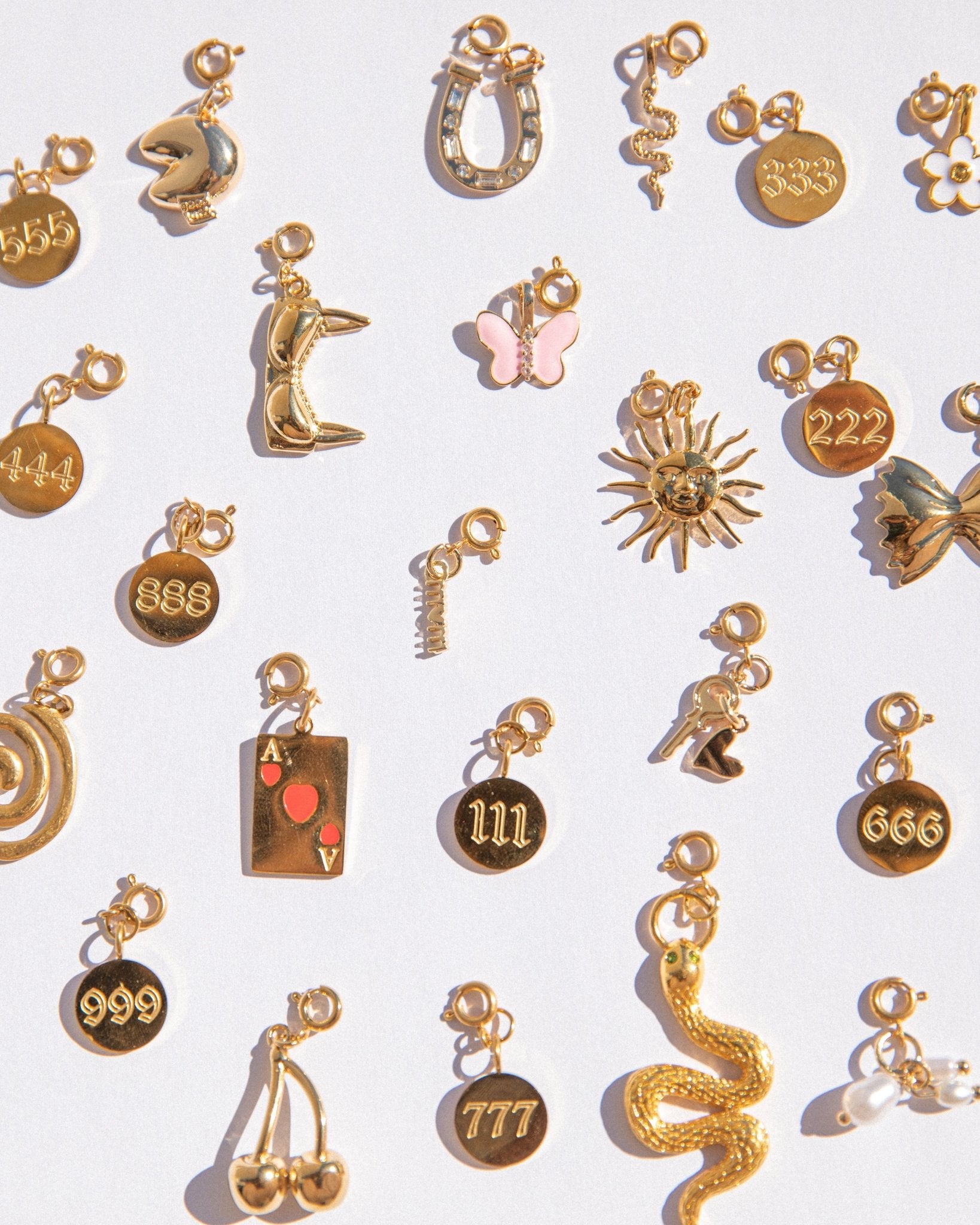 Collection of various gold charms on a white background