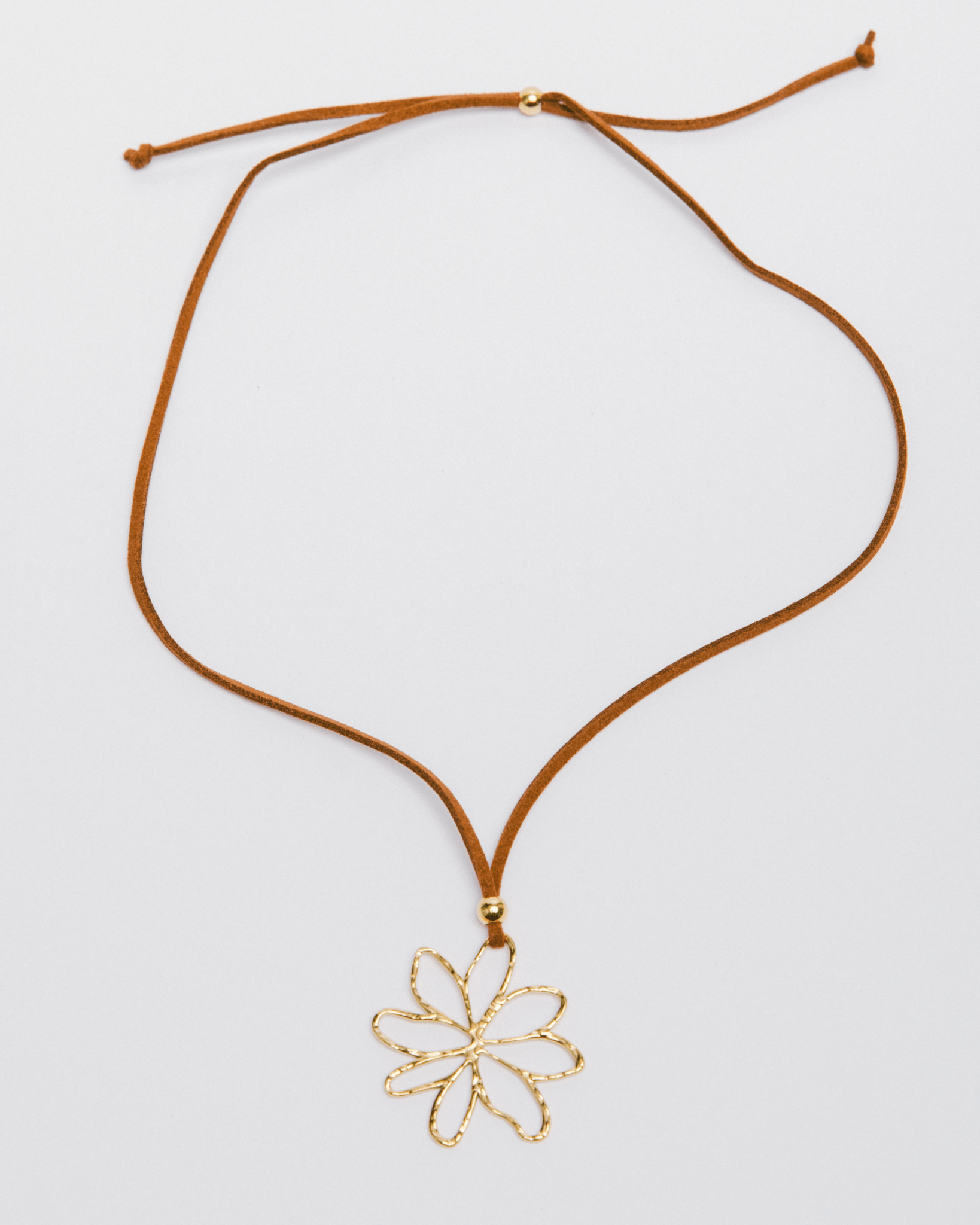 Necklace with a gold flower pendant on a white background