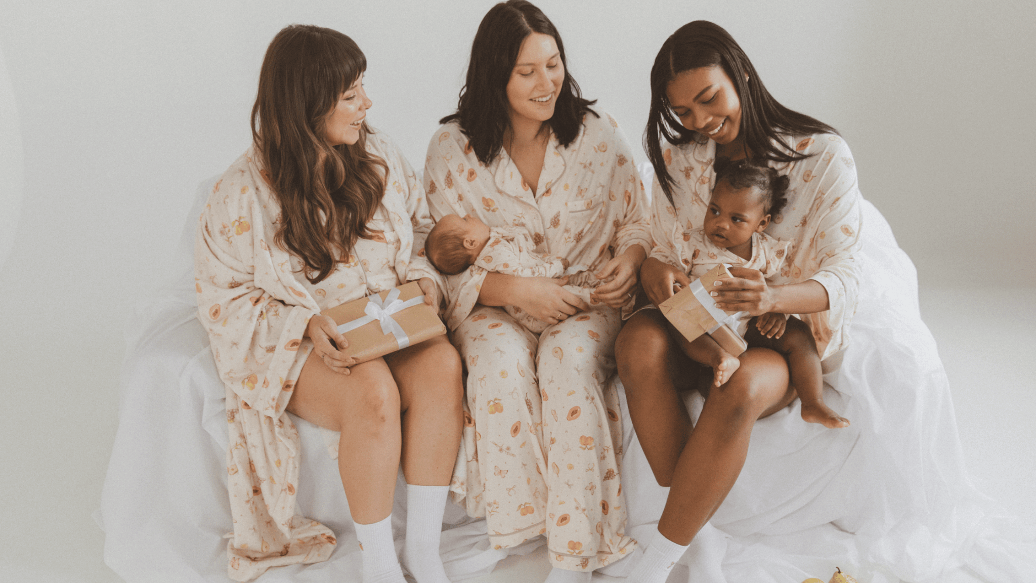Three women wearing linen printed sets, relaxed sitting on stairs outside in a fashionable manner