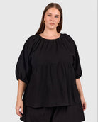 Woman wearing matching black cotton set, that is breastfeeding and bump friendly. 