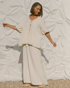 Woman wearing a summery cream coloured crepe set. 