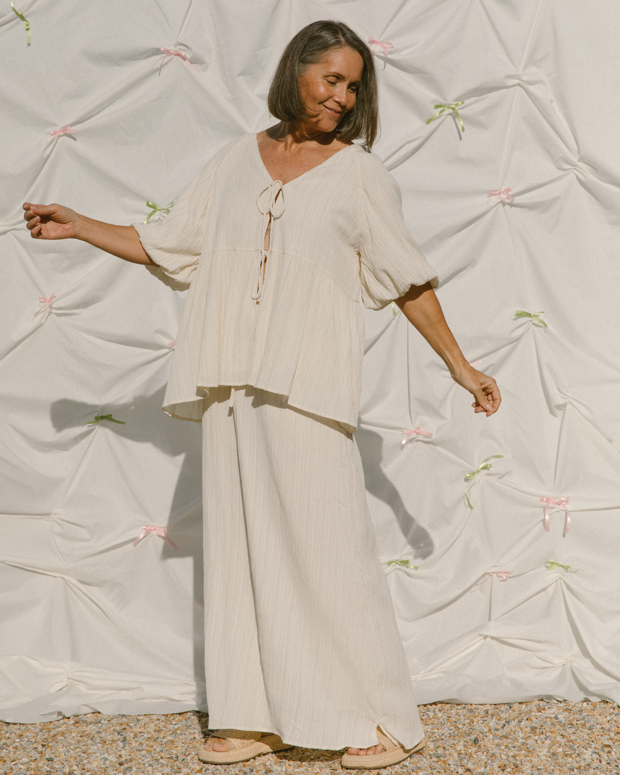 Woman wearing a summery cream coloured crepe set. 