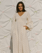 Woman wearing cottage core inspired long sleeved maxi dress with pockets. 