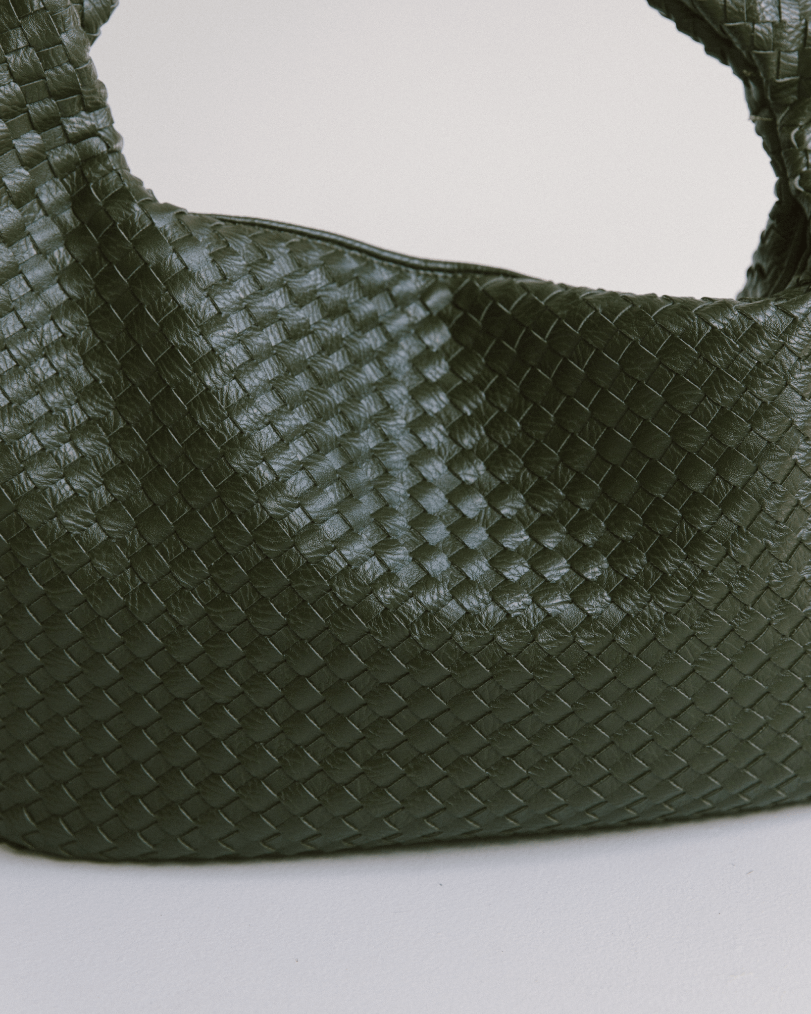 Green woven handbag on a light gray background