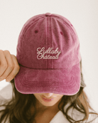 Wine coloured washed denim dad cap with scripted words on front