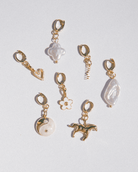 Set of gold and pearl charms on a light gray background