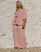 Woman wearing oversized pink co-ord set with tie-up reversible top. 