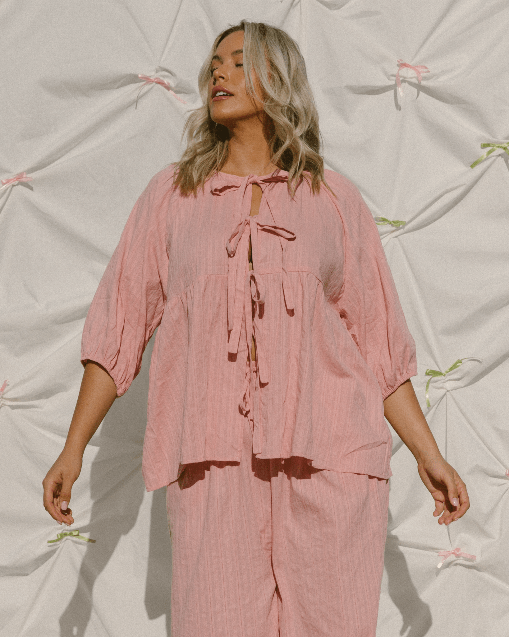 Woman wearing trendy pink tie-up top with matching long pants