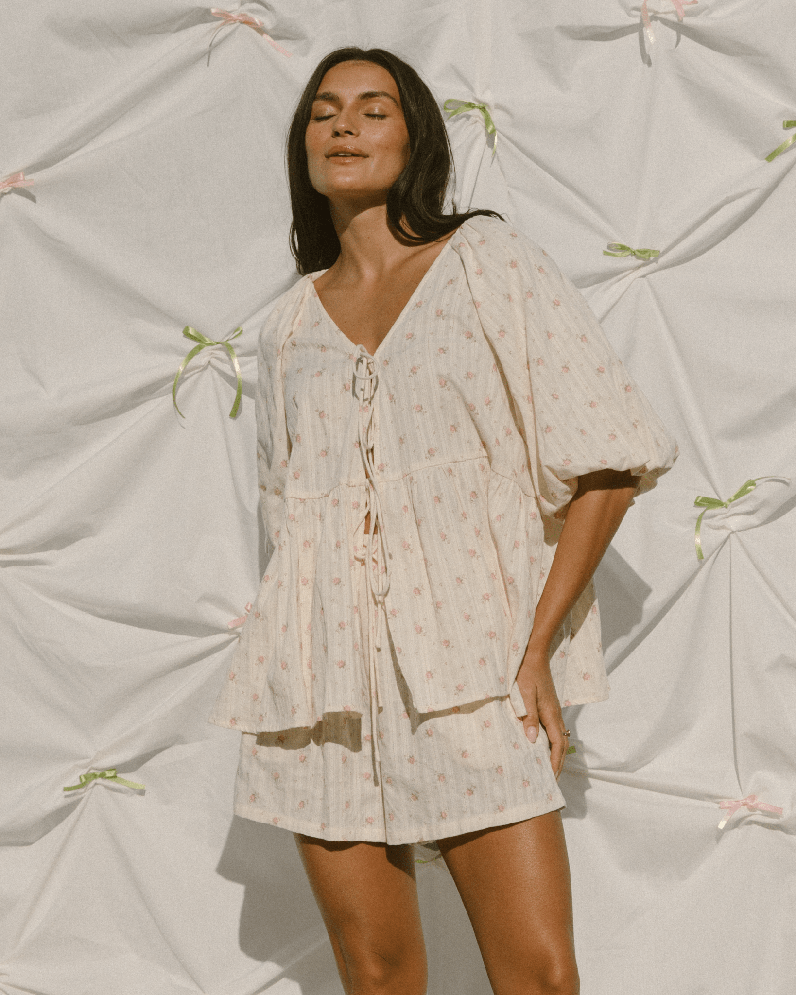 Woman wearing feminine set with tie-up top and pillow sleeves. 