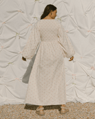 Woman wearing delicate pink flower maxi dress with a shirred bust. 