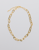 A gold paperclip chain necklace with adjustable length, laid out on a white background.