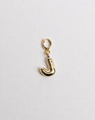 A gold-plated stainless steel charm in the shape of the letter J with a secure clasp on a white background.