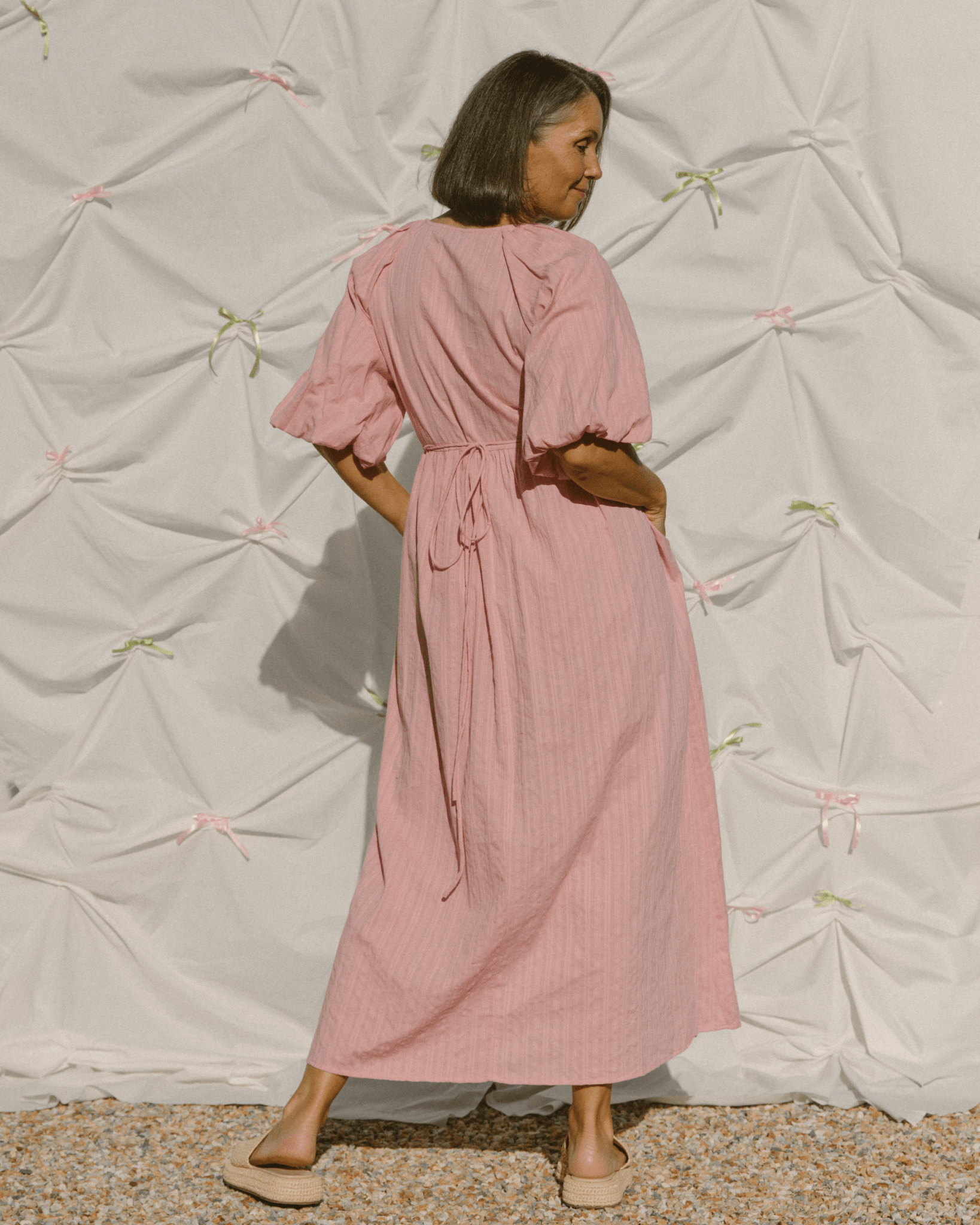 Woman wearing blush pink bump friendly wrap maxi dress. 