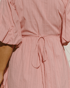 Close-up of tie-up back on pink maxi dress. 