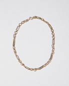 Gold chain necklace on a light gray background