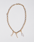 Gold chain necklace with pendant on a light gray background