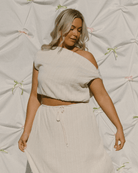 Woman wearing cream coloured co-ord set in a crinkle fabric. 