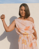 Woman wearing a flowy off the shoulder crop top in a spring floral print. 