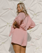 Woman wearing reverisble breastfeeding friendly fashion shirt and matching pink shorts.