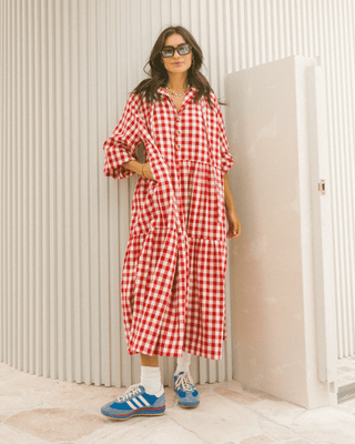 Woman in flowy postpartum-friendly maxi dress in red gingham