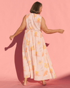 Woman wearing a floral dress against a pink background
