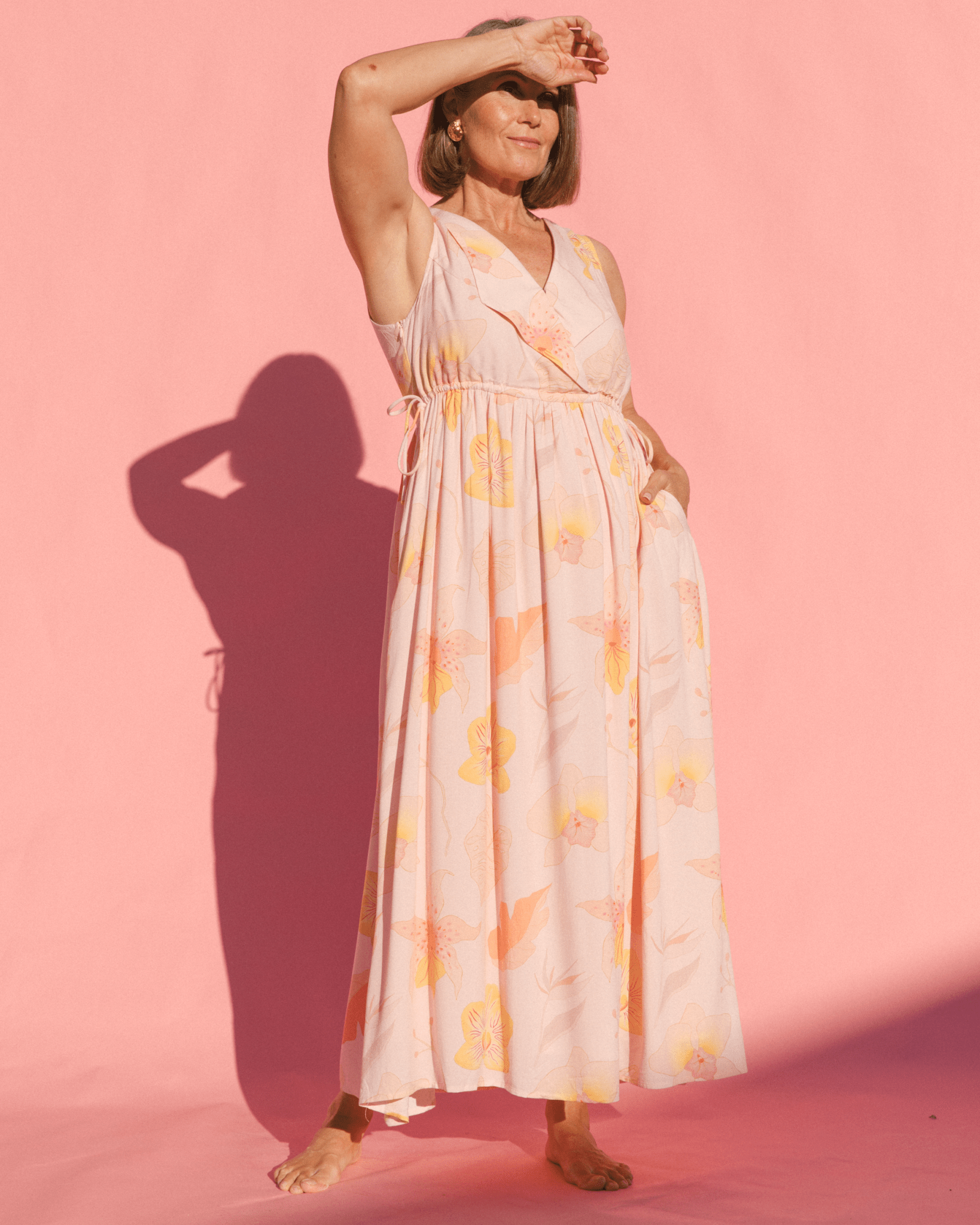 Woman wearing a maxi length spring time pink floral dress. 