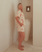 Woman wearing a pattern pj shirt & shorts. 