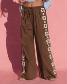 Brown cotton wide-leg pants with adjustable elastic waistband and knit star contrast detailing down the side-seam.