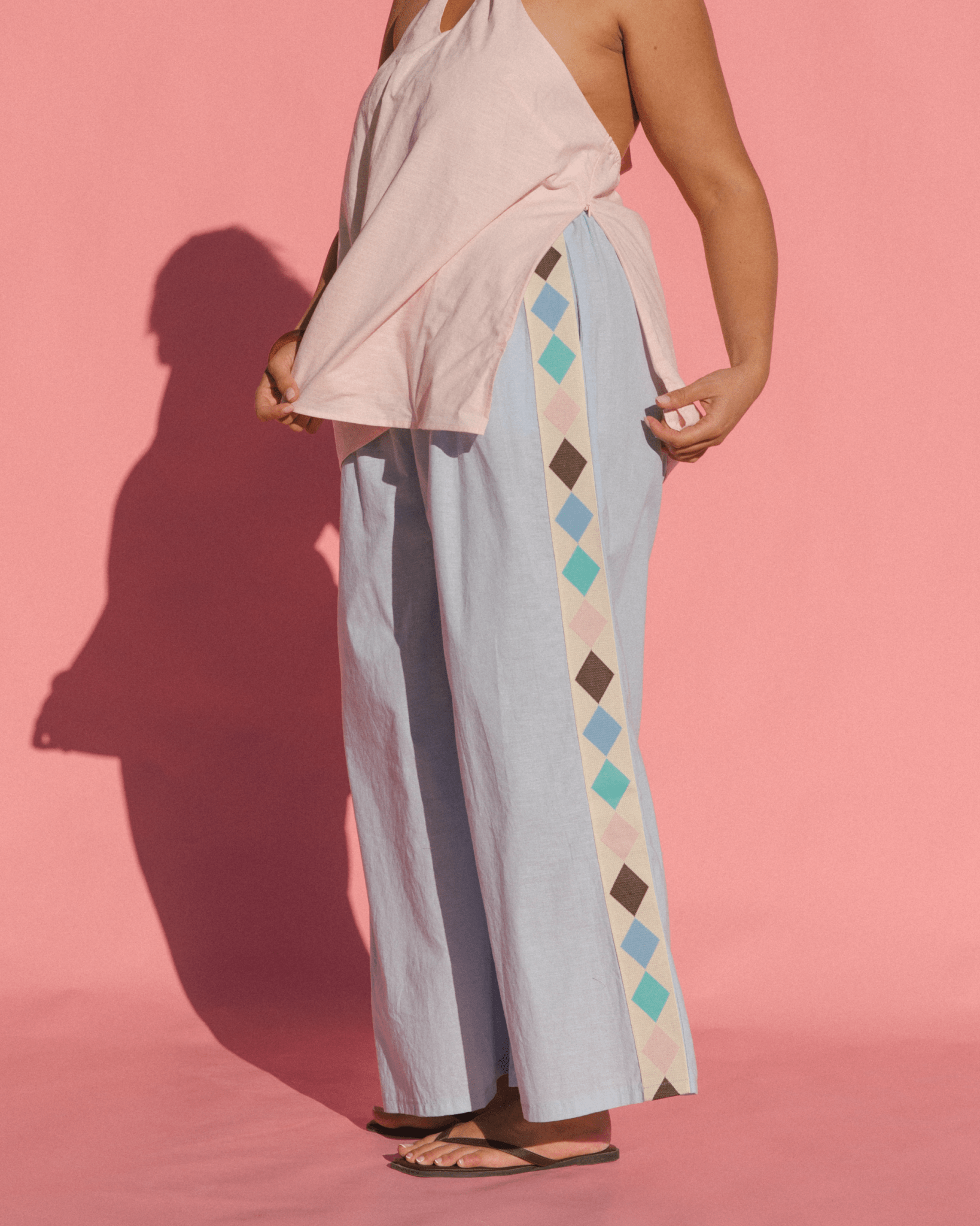 Women wearing breastfeeding friendly fashion halter top and showing the side-seam zippers for feeding access.