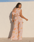 Woman wearing an off the shoulder peach coloured crop top and a wide-legged long pants