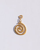 Gold spiral charm pendant on a light gray background